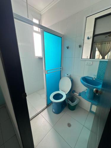 a bathroom with a blue toilet and a sink at Hotel Rodadero Suites By SGH in Santa Marta