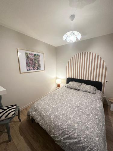 une chambre avec un lit avec une tête de lit en bois dans l'établissement Appartement Le Bourg Hypercentre WIFI, à Rodez