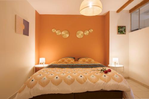 Un dormitorio con una cama con una pared naranja. en Le Ginger Tricastin, en Lapalud