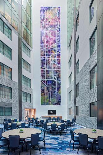 a lobby with tables and chairs and a large mural at The Royal Sonesta Washington DC Capitol Hill in Washington