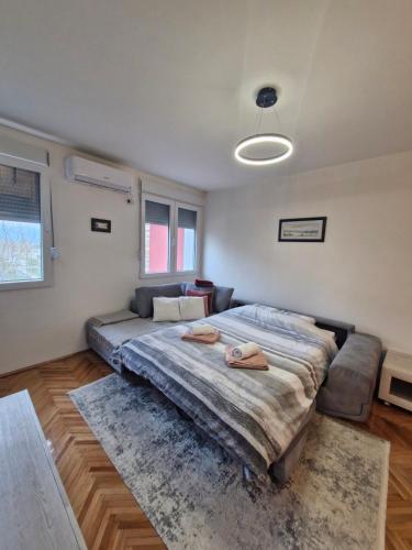 a bedroom with a large bed and a couch at ZONA apartman in Vranje