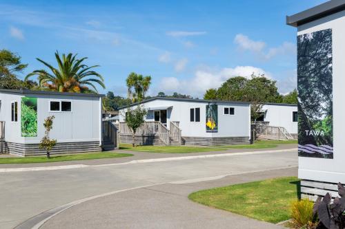 a row of white buildings on a street at Riverside Whakatane Holiday Park in Whakatane