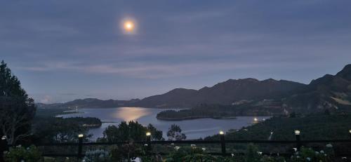 a full moon rising over a lake at dusk at Suite 1 El Palco del Neusa in Cogua