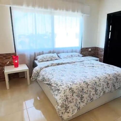a bedroom with a large bed and a window at Badr in Amman