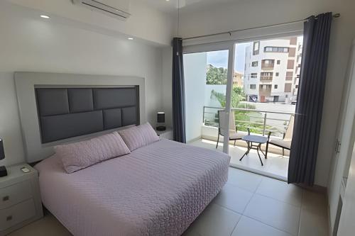 a bedroom with a bed and a view of a balcony at Departamento Hanna #3 Bucerias in Bucerías