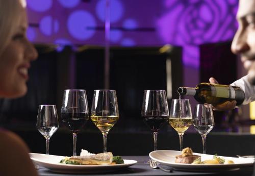 a person pouring wine into a plate of food at Temptation Cancun Resort - All Inclusive - Adults Only in Cancún