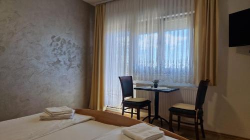 a hotel room with a bed and a table and chairs at Villa Dona Bella in Donji Bitelić