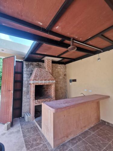 una cocina al aire libre con chimenea de ladrillo en una casa en Casa con alberca, en Tulum