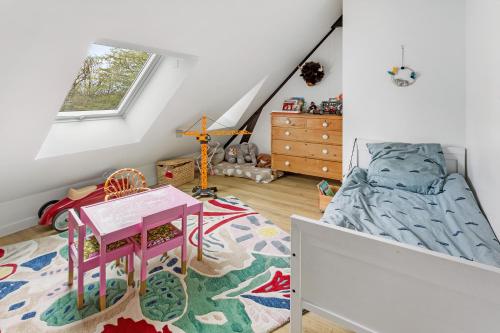 - une chambre pour enfants avec un lit et une table dans l'établissement Le Belvédère - Spacieux & Haut de gamme, à Vertou