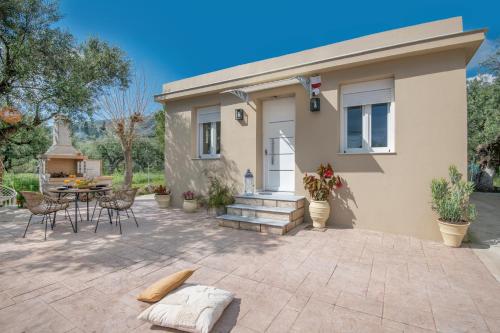 une maison avec un patio avec une table et des chaises dans l'établissement Villa Destiny, à Lagópodhon