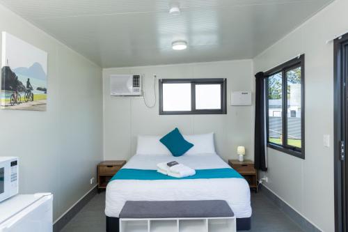 a bedroom with a bed and a window at Riverside Whakatane Holiday Park in Whakatane