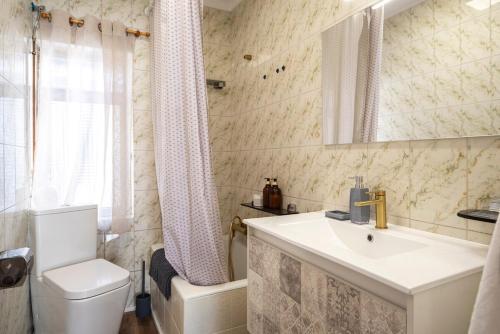 a bathroom with a sink and a toilet and a mirror at Casa Camilo Retro with Charm in Santander