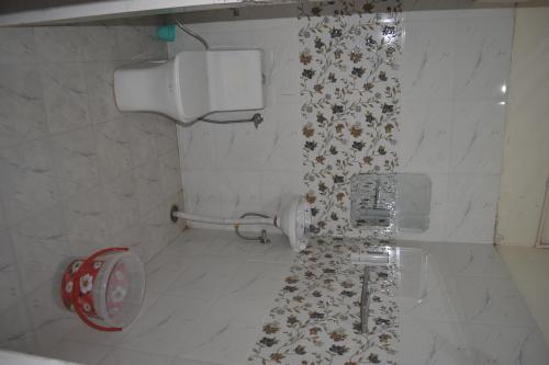 a bathroom with a toilet with a floral shower curtain at Hotel the gangotri in Varanasi