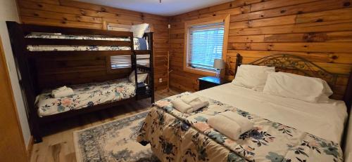 a bedroom with a bed in a log cabin at Wandering Woods- 3 Bedroom Home with Hot Tub and Firepit in Oakland