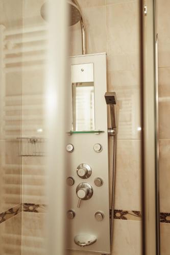 a shower with a glass door with a mirror at Moledo's Sea House in Moledo