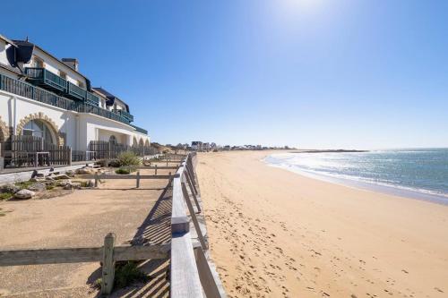 - une plage avec une clôture et l'océan dans l'établissement Studio Plage & Vacances Résidence Valentin, à Batz-sur-Mer