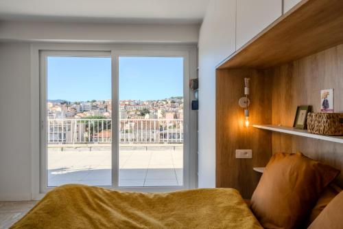 - une chambre avec une grande porte coulissante en verre offrant une vue dans l'établissement Appartement avec Terrasse et Vue Mer, à Cannes