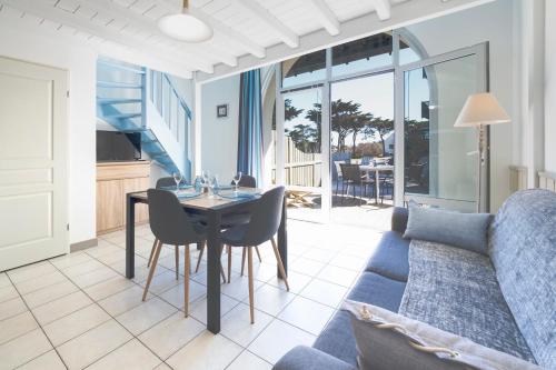 un salon avec une table et un canapé bleu dans l'établissement Studio Plage & Vacances Résidence Valentin, à Batz-sur-Mer