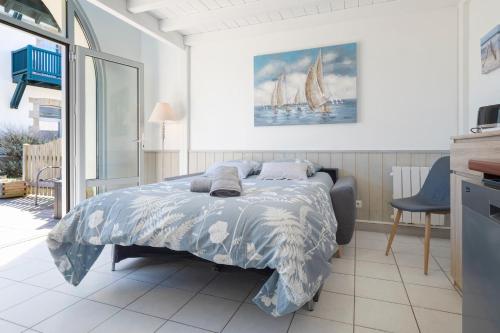 une chambre avec un lit avec une couette bleue dans l'établissement Studio Plage & Vacances Résidence Valentin, à Batz-sur-Mer