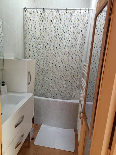 une salle de bain avec un rideau de douche et un lavabo dans l'établissement La Cuxanaise, à Cuxac-dʼAude