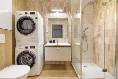 a bathroom with a washing machine and a sink at Klif Apartamenty Polanki Aqua in Kołobrzeg