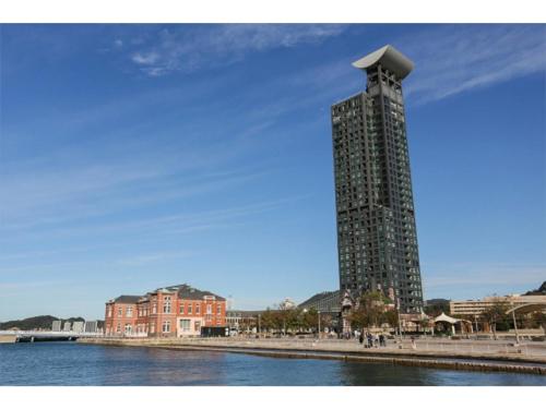 a tall tower is next to a body of water at Kokura Recent Hotel - Vacation STAY 61113v in Kitakyushu