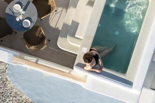 an overhead view of a person in a swimming pool at Airth Santorini Suites in Firostefani