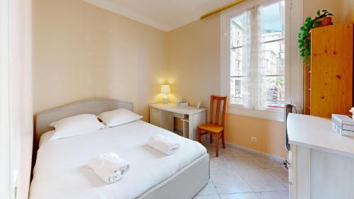 une chambre avec deux lits et un bureau et une fenêtre dans l'établissement 3 Bedroom flat, 50 metres from Monaco!, à Beausoleil