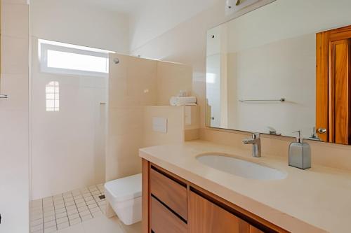 a bathroom with a sink and a toilet and a mirror at Departamento Mauricio #3 in Bucerías