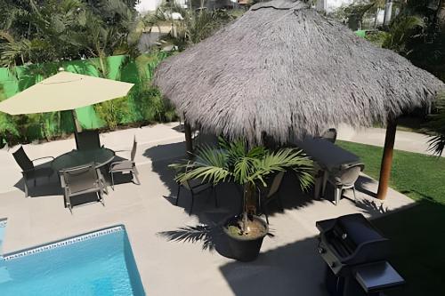 an overhead view of a resort with a pool and a straw umbrella at Departamento Mauricio #3 in Bucerías
