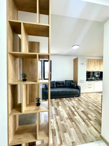 a living room with a couch and wooden shelves at North Boutique Apartments in Mamaia Nord