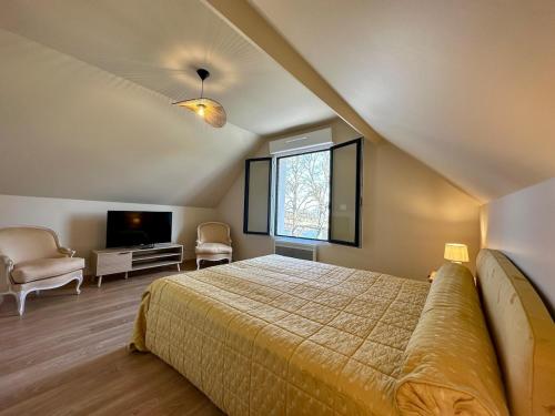 une chambre avec un lit, une télévision et une fenêtre dans l'établissement L'Ecluse de Louise, VUE SUR BAIE, à Saint-Valery-sur-Somme