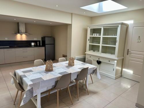 une salle à manger avec une table et des chaises dans une cuisine dans l'établissement L'Ecluse de Louise, VUE SUR BAIE, à Saint-Valery-sur-Somme