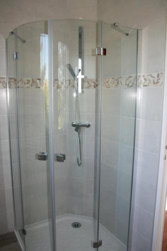 une douche avec une porte vitrée dans une salle de bain dans l'établissement Gîte la brêche des chars, à Sainte-Marie-du-Mont