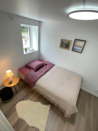 a bedroom with a large bed and a window at Charming Modern Apartment Close to Moa & Ålesund in Ålesund