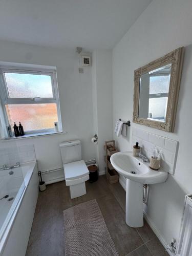 a white bathroom with a sink and a toilet at Rustic Elegance Town Centre Flat in Ipswich