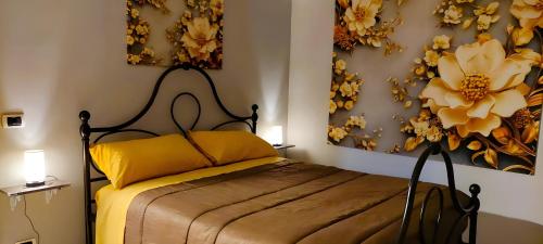 a bedroom with a bed and two paintings on the wall at La Casa di Anna in Zagarolo