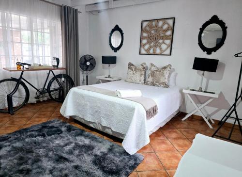 a bedroom with a bed and a bicycle and mirrors at Zhantique Guest House 1- Unit 4 in Boksburg