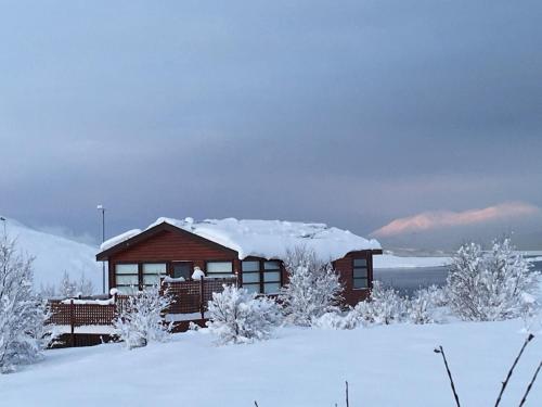 a cabin in the snow with snow on the roof at Vacation Home Fagravik in Akureyri