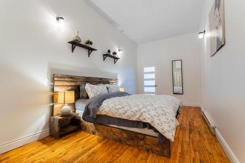 a bedroom with a large bed with a wooden headboard at Trendy 2BR Getaway in Montreal in Montréal