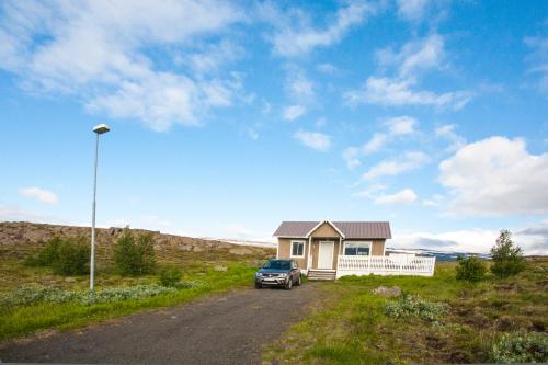 a truck parked in front of a small house at Aurora Vacation Homes Fagravik in Akureyri