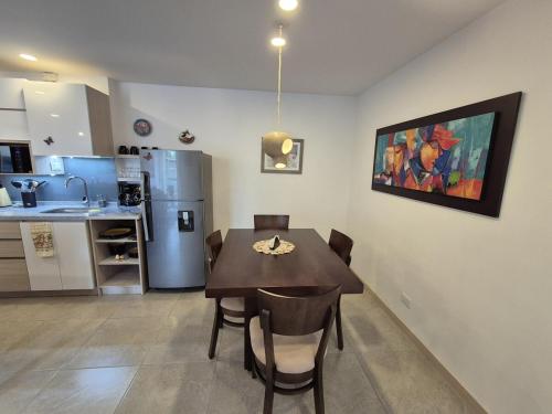 a kitchen and dining room with a table and a refrigerator at Belmonte207-Hermoso apartamento de lujo con aire acondicionado in Armenia
