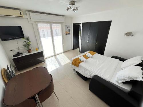 une chambre avec un lit, une chaise et une télévision dans l'établissement C067-Beau Studio a 100 m des plages et proche Palais, à Cannes