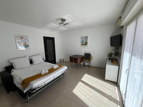 une chambre avec un lit et une table dedans dans l'établissement C067-Beau Studio a 100 m des plages et proche Palais, à Cannes