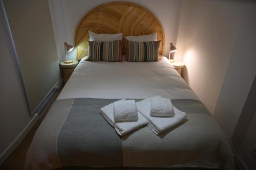 a bedroom with a bed with two towels on it at Downtown Cosy in Vila Real