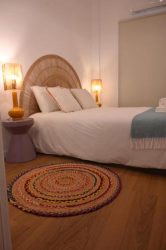 a bedroom with a large white bed with two lamps at Downtown Cosy in Vila Real