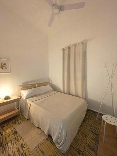 a bedroom with a bed and a table and a fan at Akaiah in Santo Domingo