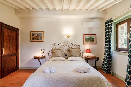 a bedroom with a large bed with two towels on it at La Capannina del Chianti in Radda in Chianti