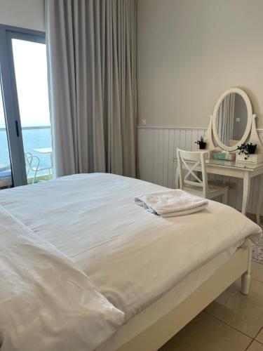 - une chambre avec un lit et une table avec un miroir dans l'établissement شقةباأطلالة بحرية برج الجوهره داماك Damac AlJawharah Tower, à Quai