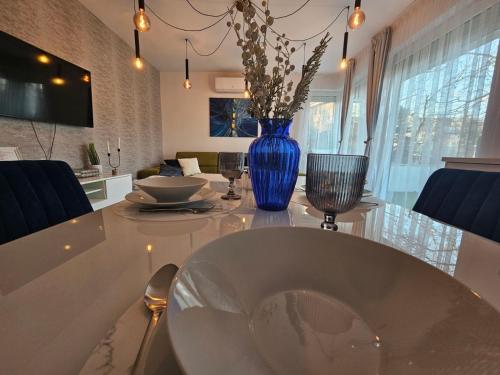 a white table with a blue vase on top of it at White Rose Hill Luxury Apartment Budapest in Budapest